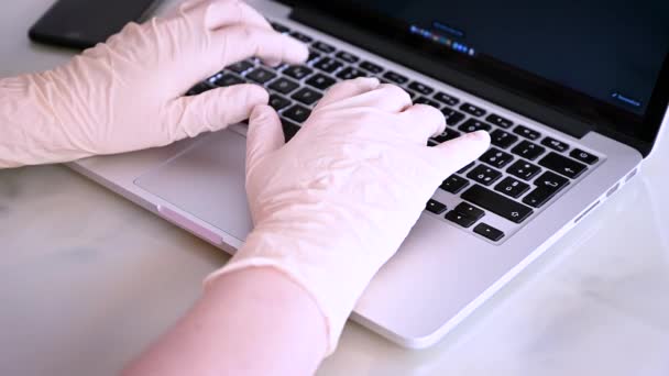 Ręka robocza z rękawicą pracująca z komputerem wpisującym na laptopie — Wideo stockowe