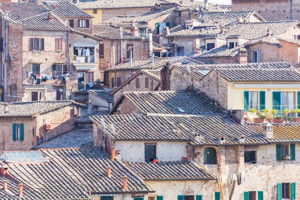 レンガとタイルで構成された家の屋根を眺め、イタリアのトスカーナ州シエナの都市建築を作り出します — ストック写真