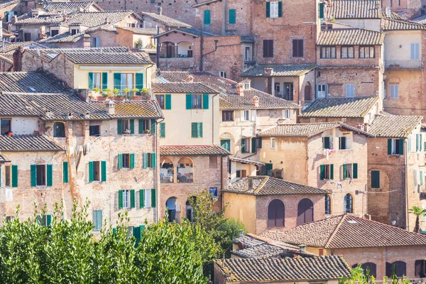 Vista sobre los tejados de las casas que consisten en ladrillos y azulejos que crean la arquitectura de la ciudad de Siena, Toscana, Italia — Foto de Stock