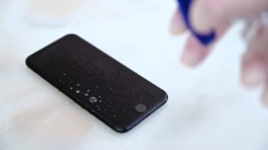 Virüs Bakterilerine karşı dezenfekte edici cep telefonu eldiven takıyor.