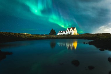 Lonely houses under northern lights, Keflavik, Iceland clipart
