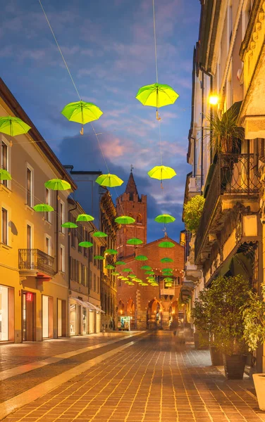 Sombrillas verdes colgadas a lo largo de la calle principal de Monza durante el atardecer, Lombardía, Italia — Foto de Stock