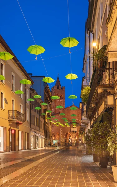 Sombrillas verdes colgadas a lo largo de la calle principal de Monza durante el atardecer, Lombardía, Italia — Foto de Stock