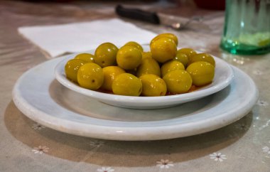 Yeşil zeytin dolu bir tabağın manzarası.