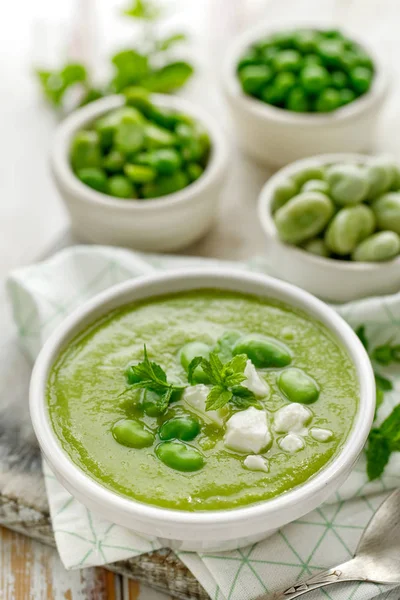 Vegetable cream soup. Broad bean soup sprinkled with fresh mint and Feta cheese. Delicious and nutritious vegetarian food. Healthy eating concept. — Stock Image Vegetable Cream Soup Broad Bean Soup Sprinkled Fresh Mint Feta Royalty Free Stock Photos