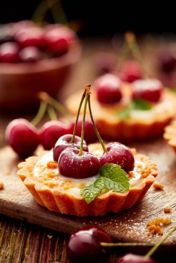 Taze kiraz ve vanilya krema ile kirazlı turta ve karamel, lezzetli tatlı ahşap bir masa üzerinde Kapat