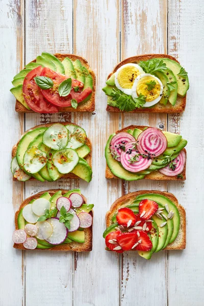 Avokado sandviç, tost Beyaz ahşap bir masa üstten görünüm üzerinde çeşitli vejetaryen soslar ile