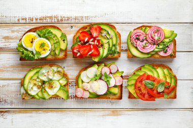Avokado sandviç, tost Beyaz ahşap bir masa üstten görünüm üzerinde çeşitli vejetaryen soslar ile