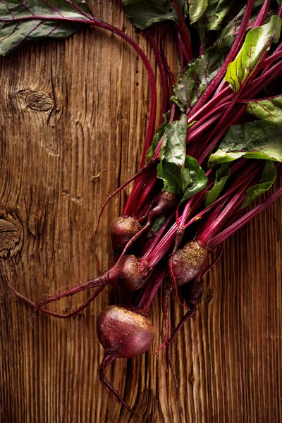 Fresh beetroots, bunch of red beets from organic cultivation on a wooden rustic table, top view