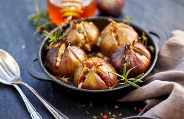 İncir Dolması gorgonzola peyniri, çam fıstığı, bal ve otlar bir karanlık siyah bir tabak içinde pişmiş, arka plan taş. Mükemmel, lezzetli, vejetaryen yemek, meze