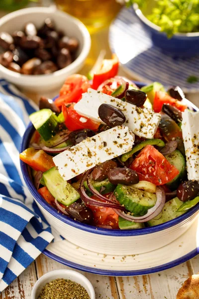 Greek salad. Traditional Greek salad consisting of fresh vegetables such as tomatoes, cucumbers, peppers, onions, oregano and olive oil, top view. Delicious, healthy vegetarian, mediterranean food