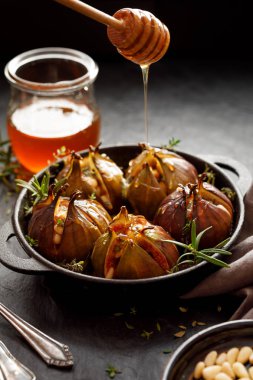 İncir Dolması gorgonzola peyniri, çam fıstığı, bal ve otlar bir karanlık siyah bir tabak içinde pişmiş, arka plan taş. Mükemmel, lezzetli, vejetaryen yemek, meze