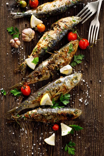 Fried fishes with addition of herbs, spices and lemon slices on a wooden background, top view. — Stock Image Fried Fishes Addition Herbs Spices Lemon Slices Wooden Background Top Royalty Free Stock Photos