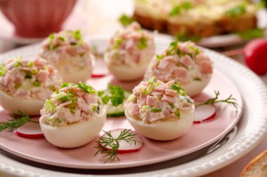 Baharatlı ve acılı yumurta, jambon füme, mayonez, yumurta sarısı ve bir plaka üzerinde taze bıçaklamak yapılmış bir hamur ile dolu yumurta dolması. Lezzetli breakfast, parti ya da tatil yemek için iştah açıcı
