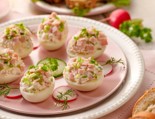 Deviled eggs, stuffed eggs filled with a paste made from smoked ham, mayonnaise, egg yolks and fresh chive on a plate.Tasty breakfast, appetizer for party or holiday meals