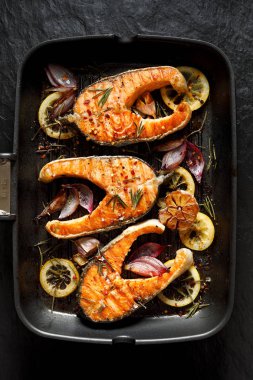 Izgara balık, limon, biberiye, sarımsak, soğan ve ızgara plaka, üstten görünüm üzerinde baharat ilavesi ile Somon ızgara biftek. 