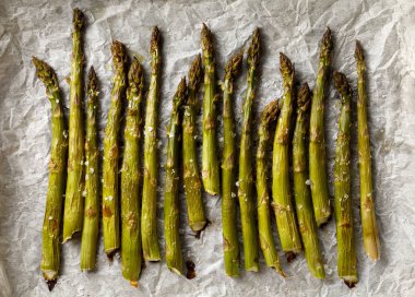 Izgara yeşil kuşkonmaz ile deniz beyaz parşömen kağıt, üstten görünüm üzerinde tuz pul serpilir. Vejetaryen yiyecekler