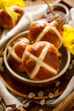 Hot cross buns, fırından yeni çıkmış sıcak cross buns ahşap rustik masa üzerinde seramik bir kasede görünümü top. Geleneksel Paskalya yemek