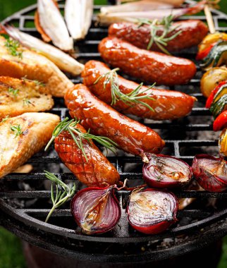 Izgara gıda, domuz sosis, baget tost ve ızgara tabağı üzerinde soğan, açık havada, üst görünümü. Barbekü, barbekü