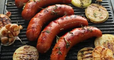 Izgara tabağına otlar ve sebzeler in eklenmesi ile ızgara sosis, açık havada, üst görünümü. Izgara yemek, barbekü, barbekü, 4k