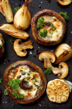 Pişmiş Portobello mantar peynir ve otlar siyah bir arka planda doldurulmuş, yakın çekim, üst görünüm. Vejetaryen yemekleri