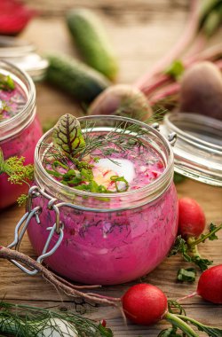 Mini cheesecake taze berry meyve eklenmesi ile çikolata ile kaplı: böğürtlen, ahududu, çilek ve nane siyah bir arka plan üzerinde bir soğutma tepsisinde, yakın çekim. Lezzetli tatlı