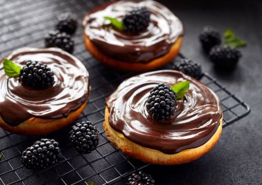 Çikolata ve böğürtlen kaplı mini peynirli kekler soğutma tepsisinde