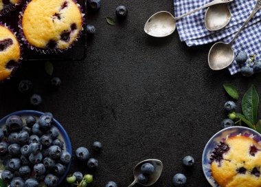 Blueberry muffins ve kopya alanı ile siyah bir arka plan üzerinde taze yaban mersini, üst görünümü, yakın çekim. Yaban mersini kekler hakkında konsept