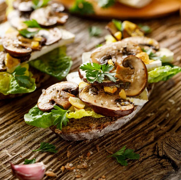 蘑菇三明治 开放式面质三明治与酸面包 加上棕色切片蘑菇 香肠奶酪 生菜和新鲜的欧芹在质朴的木制背景 — 图库照片