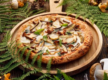 Mantar pizza, yenilebilir orman mantar (porcini mantar, chanterelle) ve mozzarella peyniri ve otlar bir orman düzenleme ahşap rustik masada eklenmesi ile pizza.