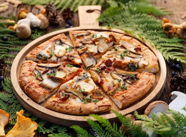 Mantar pizza, yabani yenilebilir mantar ilavesi ile pizza; porcini mantar, chanterelle ve mozzarella peyniri ve otlar bir orman düzenleme ahşap rustik masada.