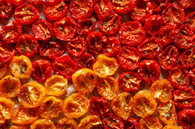 Güneşte kurutulmuş domates, kurutulmuş kırmızı ve sarı kiraz domates, yakın, üst görünümü. Güneşte kurutulmuş domates arka plan.