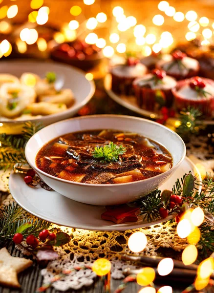 Christmas mushroom soup, a traditional vegetarian mushroom soup made with dried forest mushrooms in a ceramik plate on a festive table. Polish Christmas dinner — Stock Image Christmas Mushroom Soup Traditional Vegetarian Mushroom Soup Made Dried Forest Stock Image
