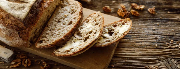 Tradycyjny Chleb Zakwaszony Plasterkach Posmarowany Masłem Pieczonym Piekarni Rzemieślniczej Drewnianym — Zdjęcie stockowe
