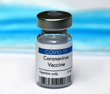Beyaz arka plan ve yüz maskesi üzerinde Coronavirus aşı şişesi