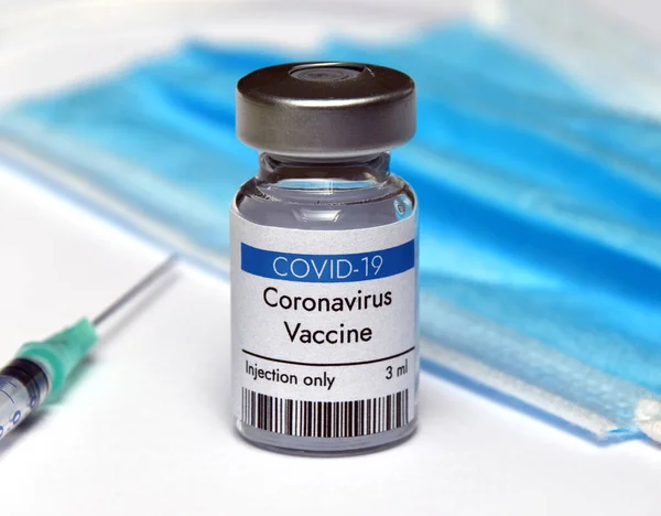 Coronavirus aşı şişesi şırınga ve yüz maskesi ile