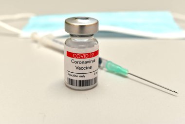 Coronavirus COVID 19 aşısı şişede ve şırıngada. Beyaz arkaplanda yakın plan.