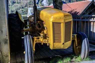 GEIRRANGER, NORway - 2017 Eylül 03. Geiranger şehrinde altın rengine boyanmış eski traktör.