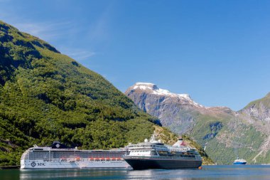 GEIRRANGER, NORway - 2016 Haziran 14. Norveç fiyordunun içinde MSC Musica ve Balmoral adlı seyir gemileri dağ zirvelerinde karla kaplı.