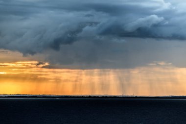 Hornsea Offshore Wind Farm, İngiltere - 13 Temmuz 2016. Ufukta güneş ışığı ve yağmurlu bulutlar var..
