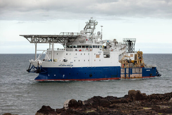 MONTROSE, SCOTLAND - 2015 MAY 13. Offshore vessel Atlantis Weller passing Scurdie Ness lighthouse, Ferryden.