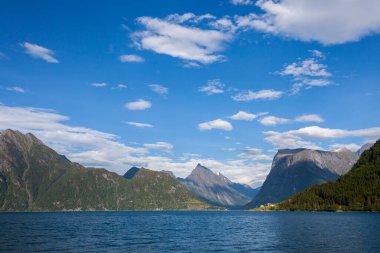 SAEBOE, NORway - 2014 JULY 08. Mavi gökyüzü ve beyaz bulutlu Norveç fiyordu ve dağı.