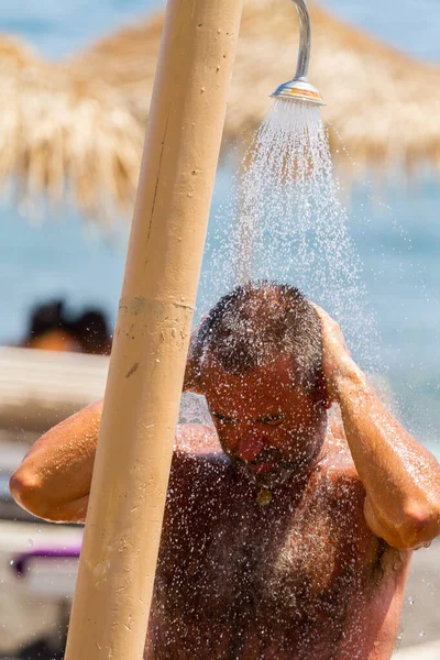 SANTORINI, GREECE - 2013 Ağustos. Kumsalda uzun bir günün ardından duş almak..