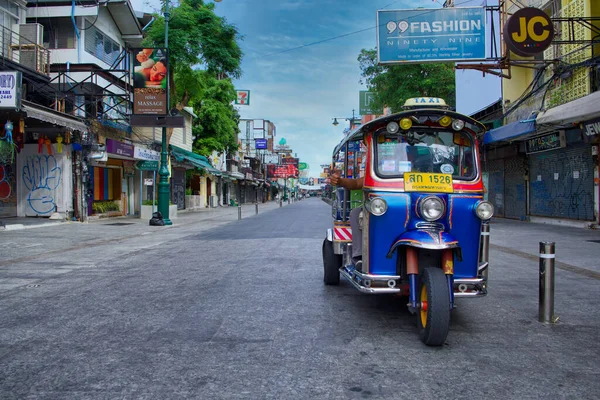 BANGKOK, THAILAND - 20-2020: Khaosarn yolunda turistlerin krallığa dönmesini bekleyen bir Tuk Tuk taksisi. Dükkanların çoğu açık bir şekilde mevcut corona virüsünden etkilenmiş..