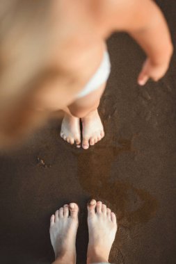 Çocuk plajda gün batımında koşar.