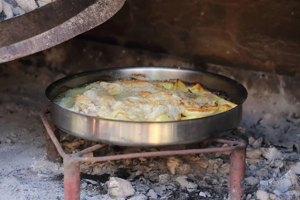 Kese altında kremalı patates ve kuzu dokusu. Sa, ekmek hamuru ya da etin pişirilmesi gereken sığ bir çan gibi büyük bir metal ya da seramik kapaktır..