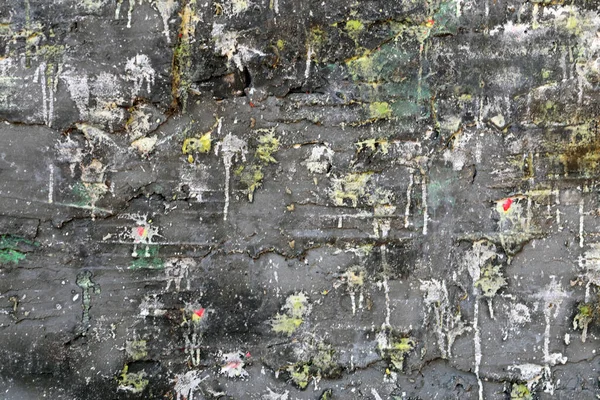 Paintball sahasının kirli duvarı. Beton duvara boya topu mermileri sıçrıyor. Pek çok paintball sıçramasının sonucu olarak kirli renkli bir arka plan..