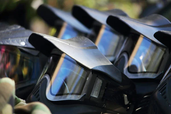 Açık havada güneşli bir günde arabanın kaputunda koruyucu paintball siyah maskeleri. Siyah koruyucu maske..
