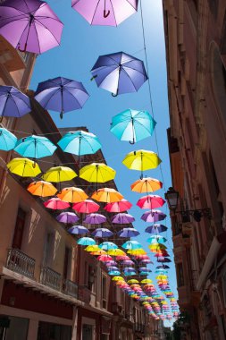 İtalya, Sardunya 'nın Iglesias ana caddesindeki renkli şemsiye manzarası. Fotoğraf 25 Temmuz 2020 'de çekildi..