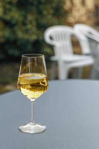 a glass of white wine on a table in a summer cafe closeup